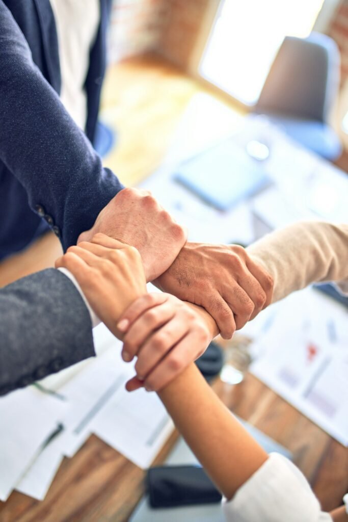 zipwp-image-y5bvrlccx8k Group of business workers standing with hands together doing symbol at the office