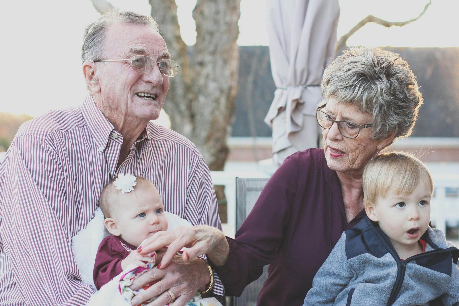pexels-photo-302083-302083 Grandparents spending joyful moments with their grandchildren in an outdoor setting, captured candidly.